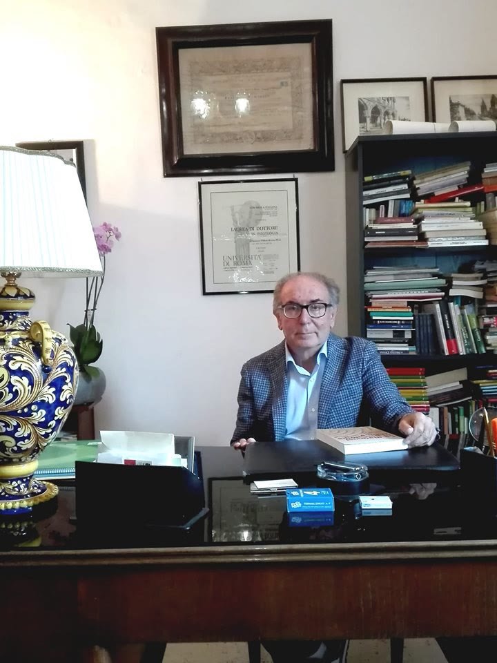 Il Dott. Roberto Fanciano seduto alla scrivania nel suo studio a Nardò, tra libri e legno